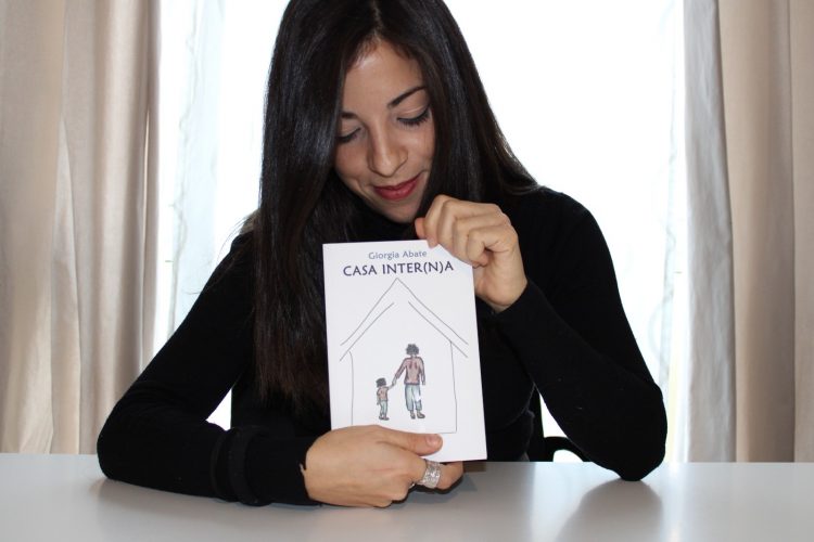 Giorgia Abate tiene in mano il suo romanzo Casa Inter(n)a