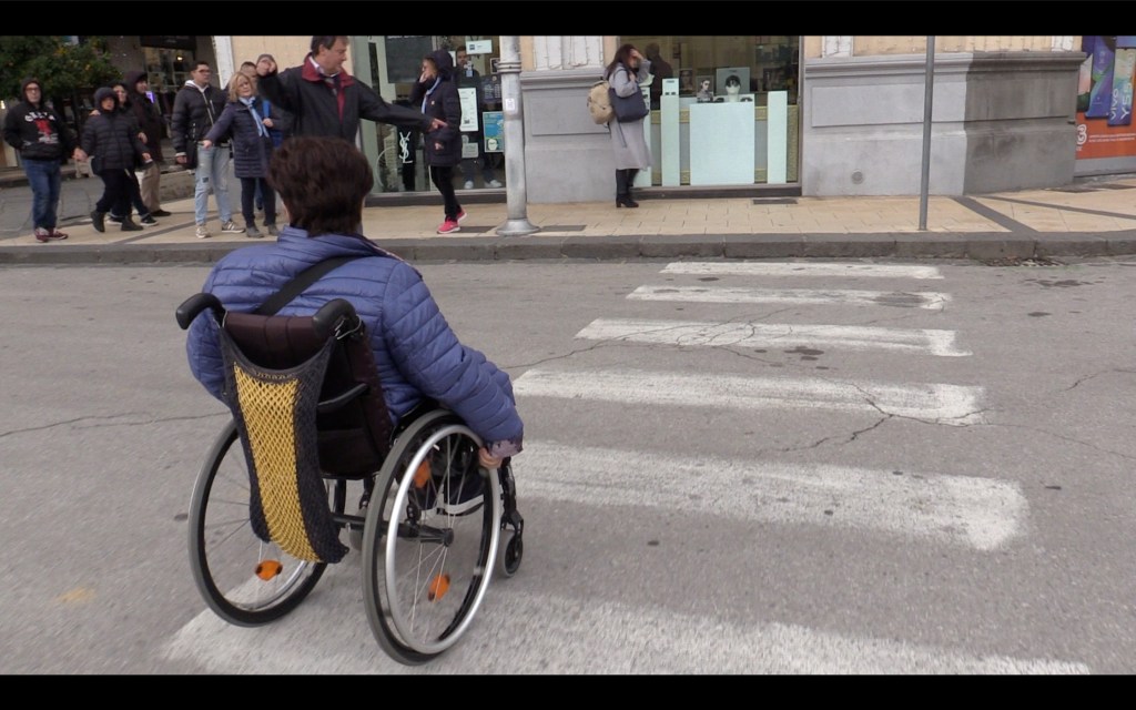 Una persona in carrozzina a Messina attraversa sulle strisce pedonali
