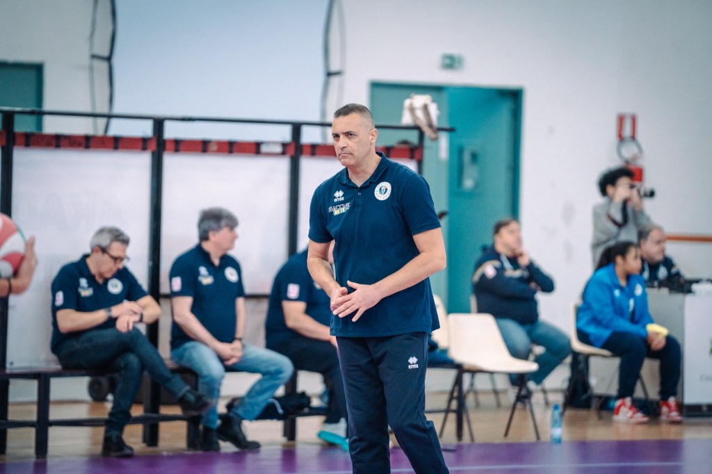 coach bonafede in piedi davanti la panchina