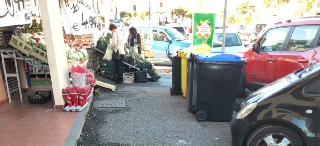 Espositori di frutta tra marciapiede e strada