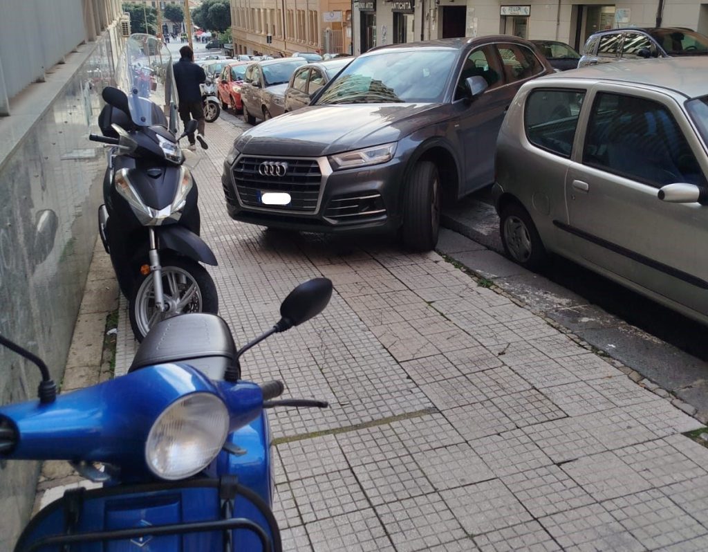 Marciapiede occupato da auto e scooter